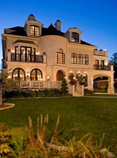 a large white house with lots of windows and balconies on the second story