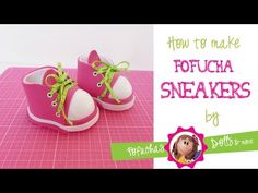 a pair of pink shoes sitting on top of a table next to a green ribbon