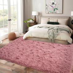 a bedroom with a large pink rug on the floor