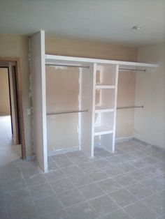 an empty room with white shelves and tile flooring in the process of being remodeled