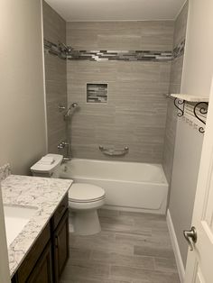 a white toilet sitting next to a bath tub in a bathroom