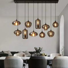 a dining room table with chairs and lights hanging from the ceiling