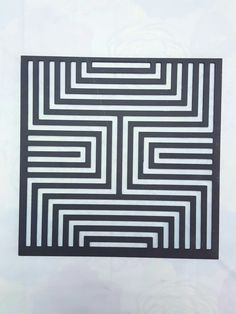 a black and white square shaped artwork on a wall in the shape of a maze