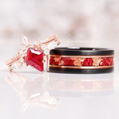 two wedding bands with red and white diamonds on them, one has a pink diamond in the middle