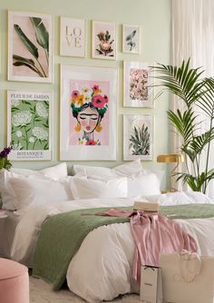 a bedroom with green walls and pictures on the wall above the bed, along with a pink ottoman