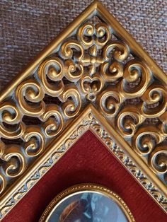 an ornate gold and red frame holds a portrait of a young woman in profile,