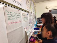 two children are writing on a white board