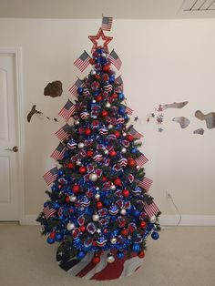 a decorated christmas tree with red, white and blue decorations in the shape of an american flag