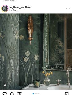 a bathroom sink sitting under a mirror next to a green wall