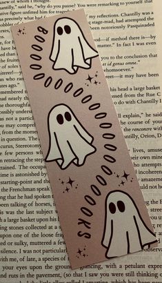 some stickers with ghost faces on them are sitting on top of an open book