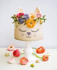 a cake decorated with flowers and a cat's face