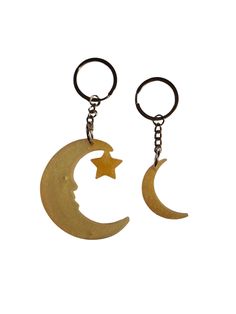 two key chains with the moon and star hanging from each one's sides,