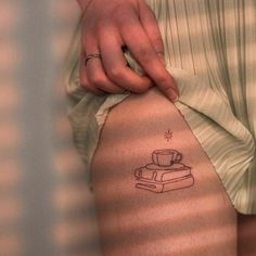 a woman's leg with a coffee cup tattoo on her left side ribcage