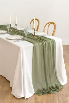 the table is set with white and green linens