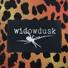 a black and orange animal print with the word widowdusk on it's back