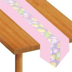 a pink table runner with hearts on it and a wooden chair at the end is shown