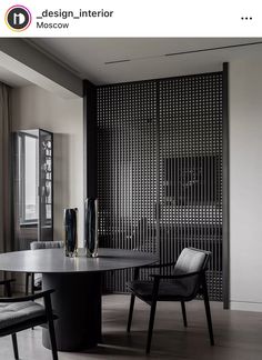 a dining room table with two chairs and a vase on the table in front of it