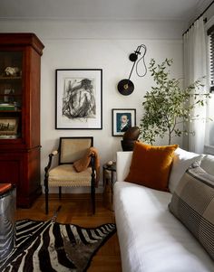 a living room filled with furniture and pictures on the wall