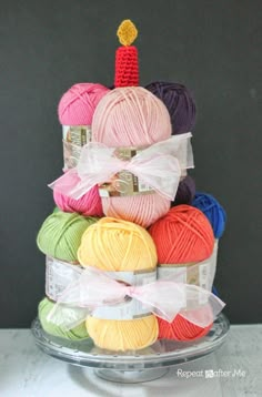 a stack of balls of yarn sitting on top of a glass platter filled with crochet