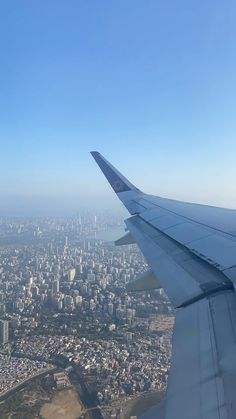 the wing of an airplane flying over a city