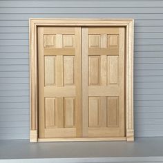 two wooden doors sitting next to each other on top of a shelf in front of a blue wall