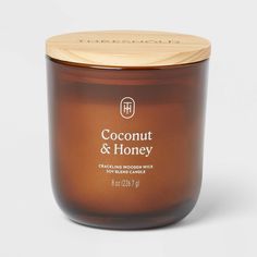 coconut and honey candle with wooden lid on white background, closeup view from the front