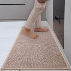 a person standing on top of a rug in a kitchen