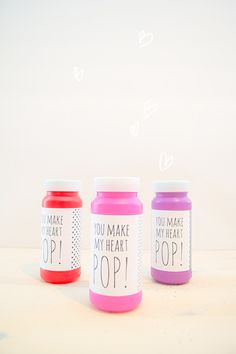 three different colored jars with some writing on them