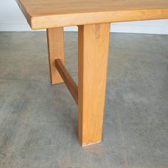 a wooden table sitting on top of a cement floor