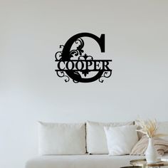 a living room with a white couch and black wall decal that reads'cooper '