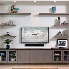 a flat screen tv sitting on top of a wooden entertainment center in a living room