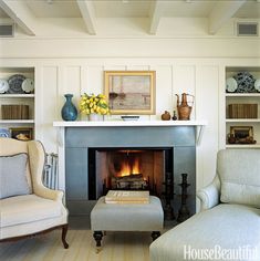 a living room filled with furniture and a fire place under a painting on the wall