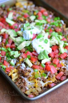 a casserole dish with meat, vegetables and sour cream on top is ready to be eaten