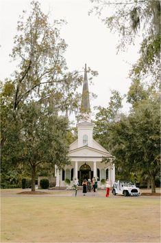 people are standing in front of a white church