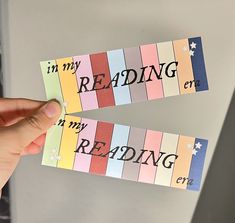 someone is holding up some reading paper with writing on it and the words in my reading center are multicolored