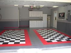 a garage with checkered flooring and white cabinets on the walls is painted black and white