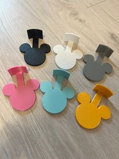 several mickey mouse shaped magnets sitting on top of a wooden table