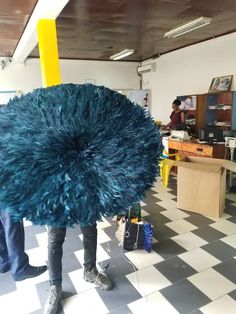 a person standing in a room with a large blue thing on his head and legs