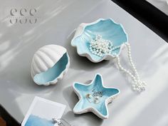 three starfish shaped dishes on a table with pearl necklaces and pearls in them