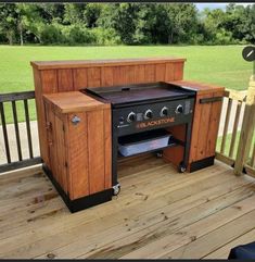 an outdoor bbq grill sitting on top of a wooden deck