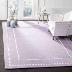 a purple rug with white trim in a living room