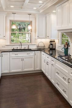 a kitchen with white cabinets and black counter tops