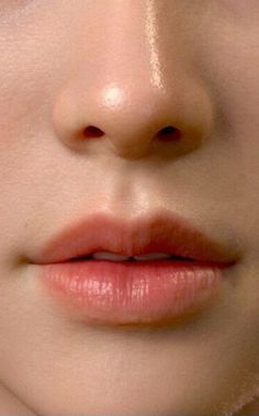 a close up photo of a woman's face with her eyes closed and lips slightly open