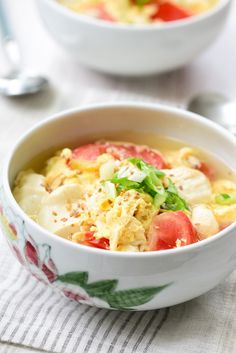 two bowls filled with food on top of a table