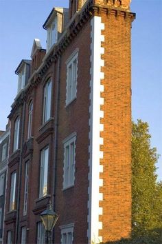 a tall brick building with a clock on it's side