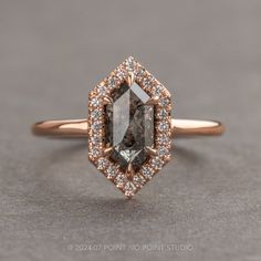 an engagement ring with a brown and white diamond in the center on a gray surface