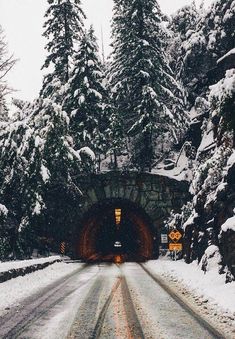 a snow covered road leading into a tunnel