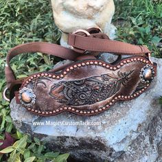 a brown leather belt sitting on top of a rock