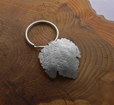 a leaf shaped metal object sitting on top of a wooden table