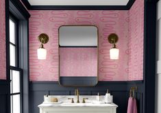 a bathroom with pink wallpaper and gold fixtures, along with a white vanity topped with a mirror